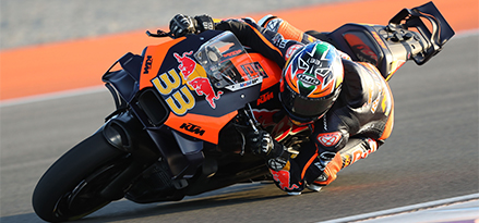 Motard pilotant une moto Red Bull très rapidement