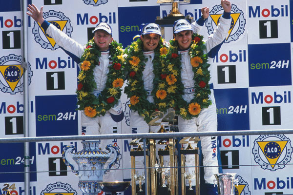Allan McNish, Stéphane Ortelli, Laurent Aiello sur le podium devant un logo Mobil 1 au Mans 1998