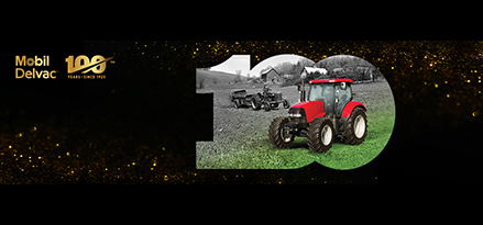 Un vieux tracteur et un tracteur rouge neuf dans un champ avec des étincelles dorées