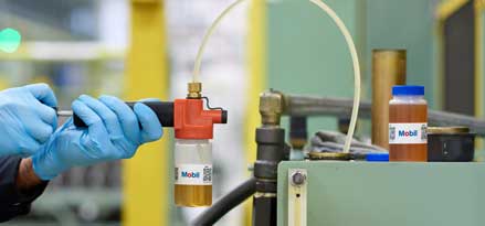 Un ingénieur Mobil prélève un échantillon pour l’analyse Mobil Lubricant Analysis