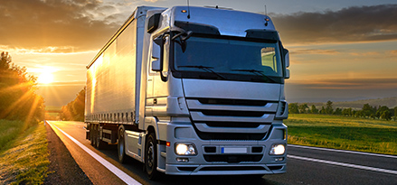 lorry drives away from sunset